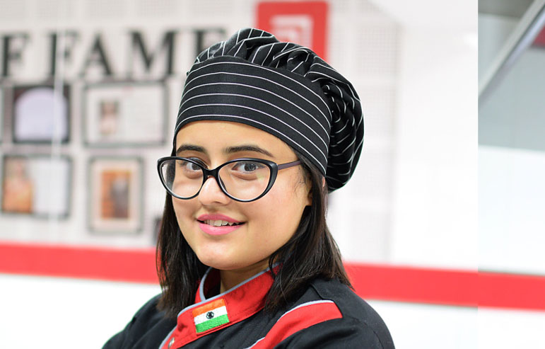 The illustration with a blurred background and a chitkara university logo shows a girl student in hospitality management.