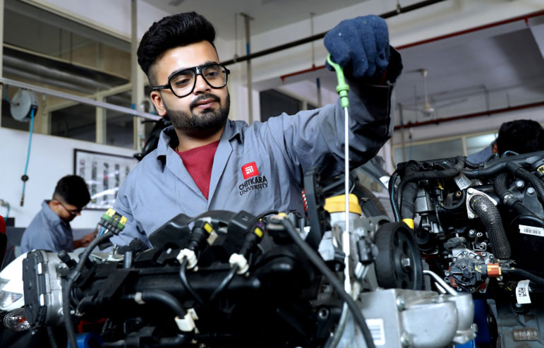 The image shows the students of chitkara university in grey jackets working on the machines.