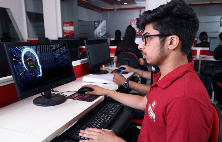 The illustration shows the students in red t-shirt from chitkara university working on their destops.