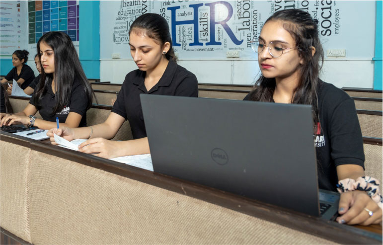 The image shows the students of chitkara university working on the laptops.