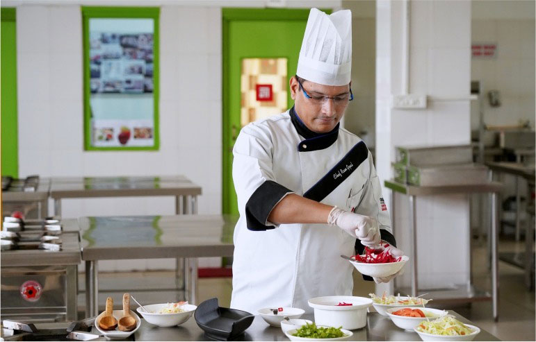 The image shows the chef cooking food in a kitchen.