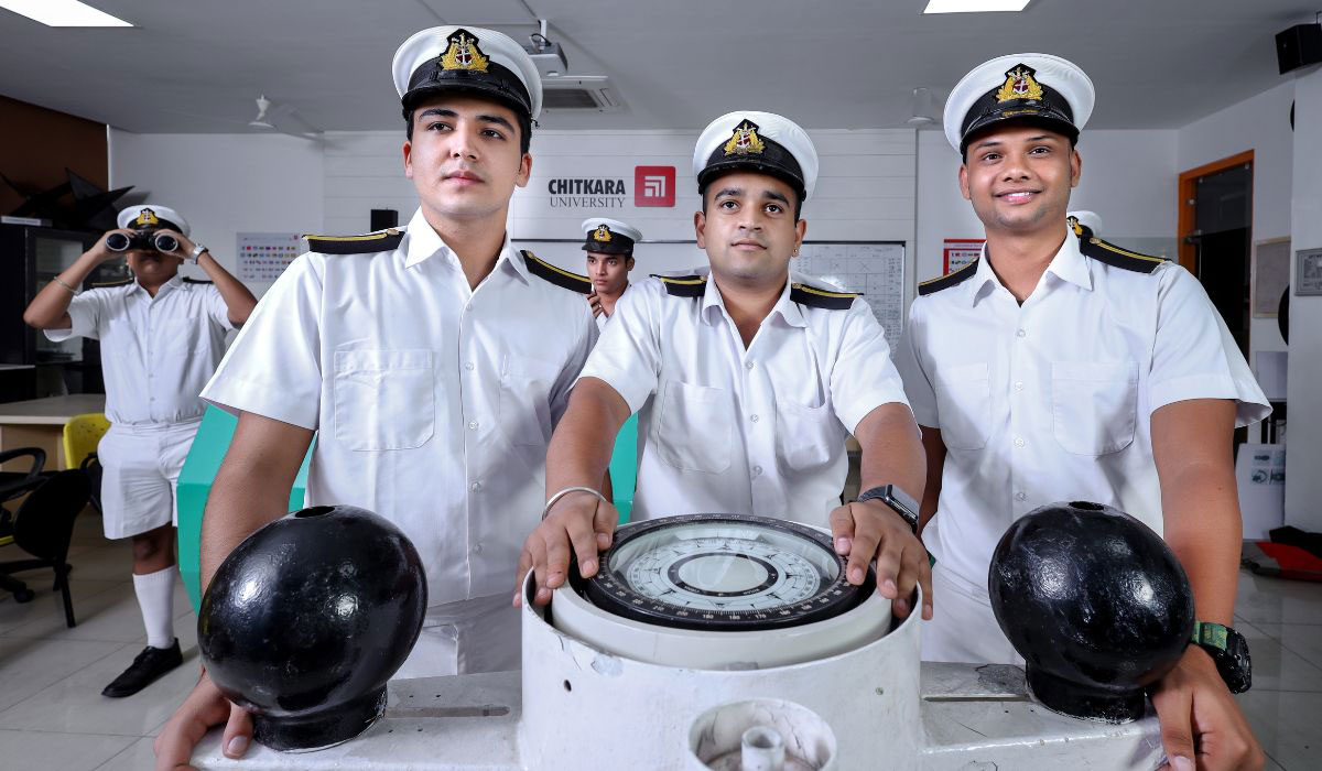 Nautical Science students at Chitkara University pursuing a career in the merchant navy, practicing ship navigation in the maritime training lab while wearing officer uniforms.