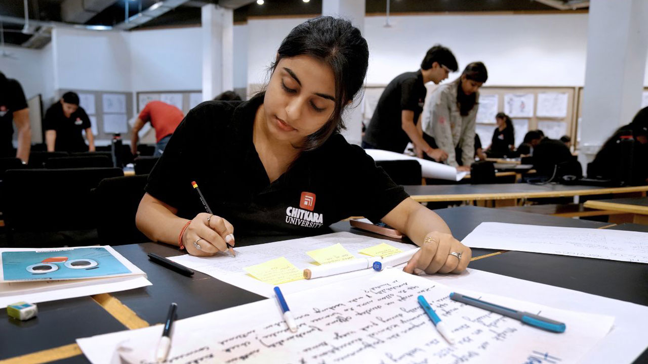 A Product Design student at Chitkara University working on concept sketches and project development in a creative classroom environment.