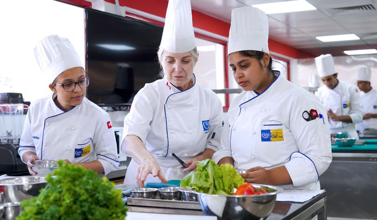 Students pursuing a Degree in Culinary Arts practicing cooking skills with an instructor at George Brown College kitchen.