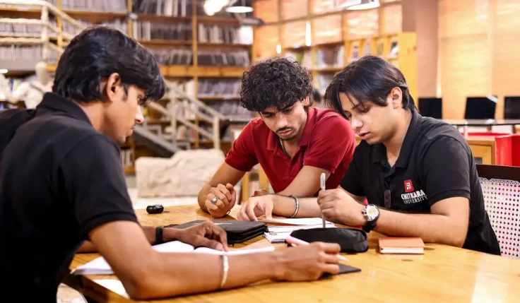 Chitkara University students reviewing B.Arch course eligibility notes in the campus library