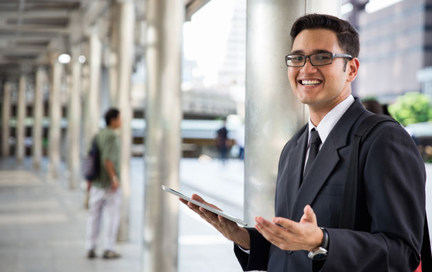 A student smiling while viewing the Online MBA in Finance overview on a laptop at Online ChitkaraU