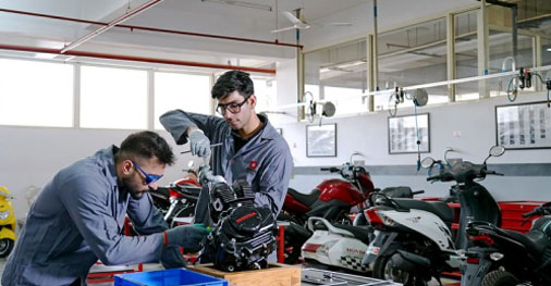 Students performing bike maintenance and diagnostics in automobile engineering lab