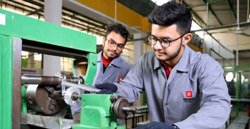 Students working on heavy automotive machinery and equipment in workshop