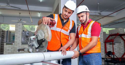 B.E. in Civil Engineering with AI & ML students cutting pipe in construction lab