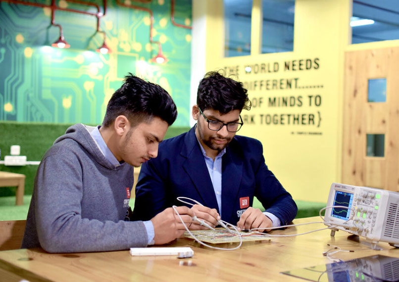 Students testing electronic circuits using oscilloscope in Electronics & Communication Engineering lab