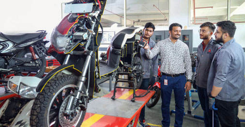 Students collaborating on mechanical engineering projects in workshop
